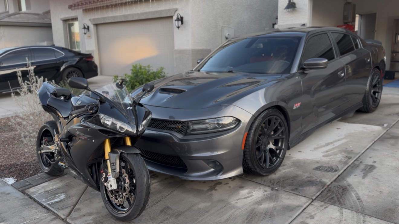 Grey Dodge Charger Scat Pack and a Yamaha R1 detailed in a driveway