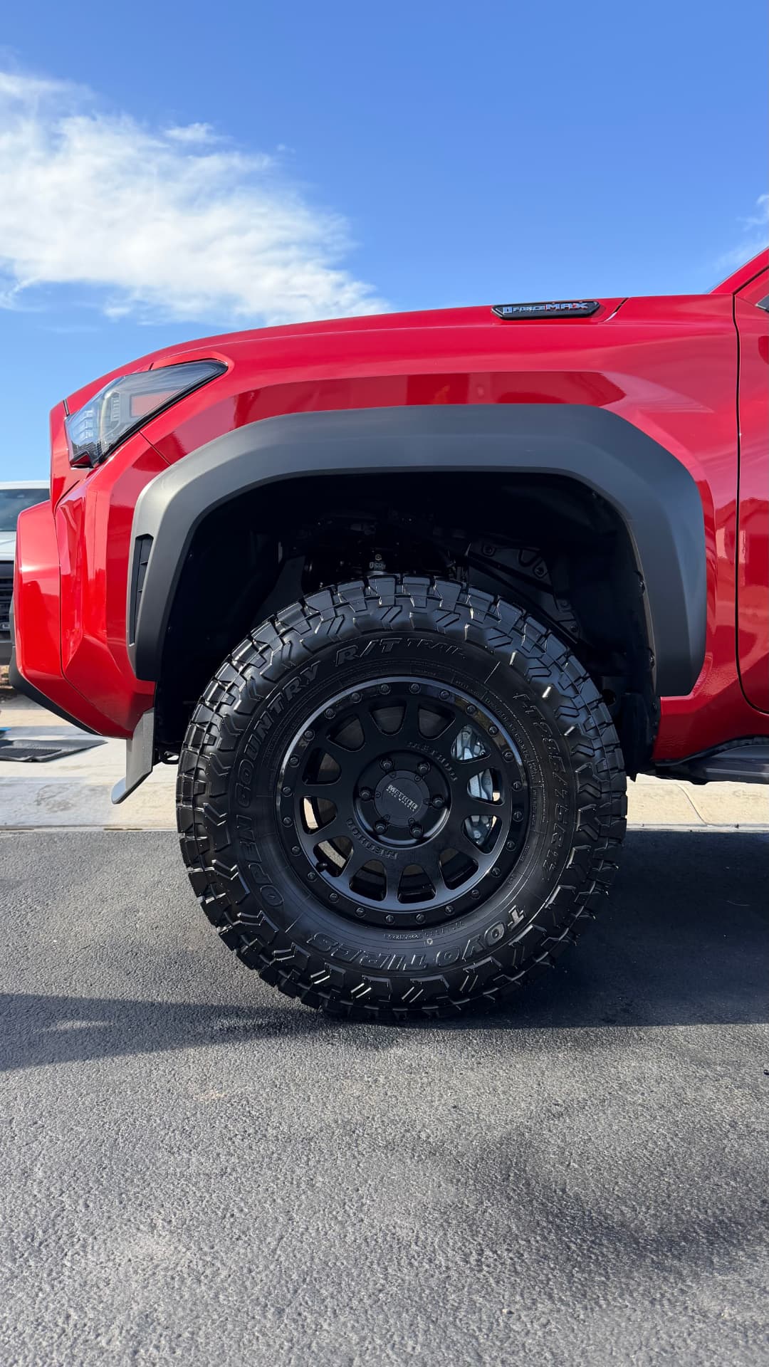 Red Toyota Tacoma with freshly cleaned black wheel and dressed tire