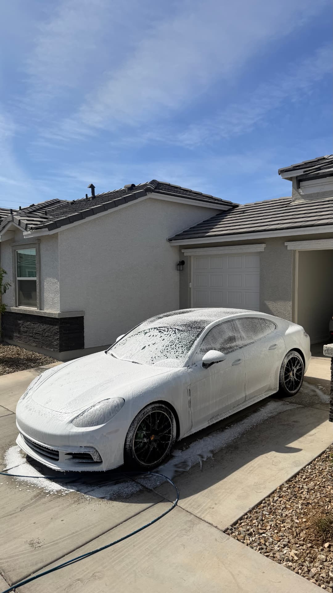 Porsche Panamera covered in thick snow foam in a Valley driveway